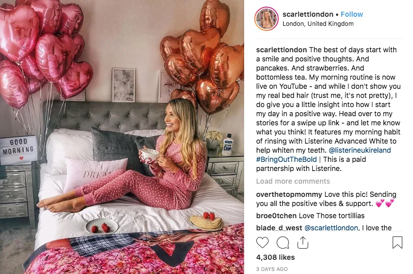 YouTube brand partnership deals: image shows influencer @scarlettlondon sitting on a bed in pink PJs, holding a coffee in a heavily staged Instagram photo. 