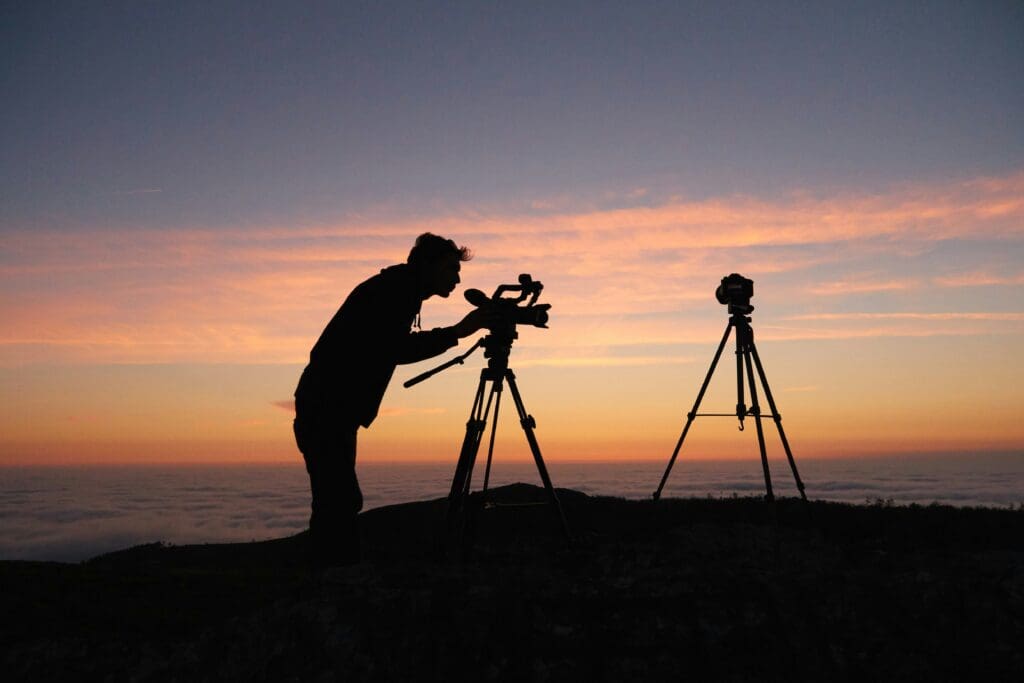 Videographer using a tripod at sunset