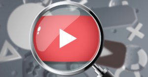 Magnifying glass enlarging YouTube play button icon to symbolize finding and analyzing low competition YouTube keywords for video search optimization